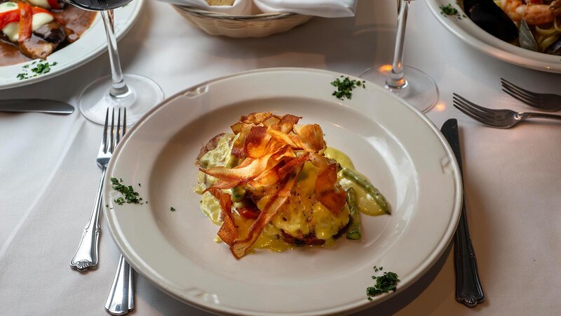 Chicken entree with asparagus and topped with fried potatoes